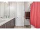 Modern bathroom with double sink vanity, a white door, and a shower with a coral shower curtain at 3142 W 20, Denver, CO 80211