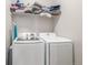 Functional laundry area with modern washer and dryer, plus shelving for storage and household towels at 3142 W 20, Denver, CO 80211