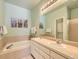 Serene bathroom with a soaking tub, double sinks, tile surround and stylish fixtures at 12819 E Dickensen Pl, Aurora, CO 80014