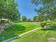 Expansive community green space featuring lush grass, mature trees, and rock retaining walls at 12819 E Dickensen Pl, Aurora, CO 80014