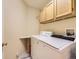 Efficient laundry room with a modern washer and dryer, overhead storage, and a convenient folding counter at 12819 E Dickensen Pl, Aurora, CO 80014