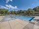 Community pool with clear blue water, surrounded by mature trees, ample seating, and well-maintained grounds at 12819 E Dickensen Pl, Aurora, CO 80014