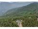 Wide aerial view of a stunning forest with the home and outbuildings nestled in the middle at 1472 Sinton Rd, Evergreen, CO 80439