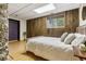Tranquil bedroom with wood-paneled walls, a cozy bed, and ample natural light from a nearby window at 1472 Sinton Rd, Evergreen, CO 80439