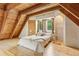 Well-lit bedroom featuring wood floors, exposed beams, closet storage and bedside tables at 1472 Sinton Rd, Evergreen, CO 80439