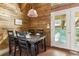 Inviting dining space with wood paneling, modern lighting, and access to the outdoor area at 1472 Sinton Rd, Evergreen, CO 80439