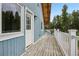 Side view of a blue home with a white door, and a long wooden deck with white railings at 1472 Sinton Rd, Evergreen, CO 80439