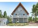 Two-story home with a white balcony and matching white doors, surrounded by rock landscaping and trees at 1472 Sinton Rd, Evergreen, CO 80439