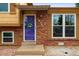 Close-up of the home's entry, featuring a vibrant door and attractive brickwork at 18130 E Asbury Dr, Aurora, CO 80013