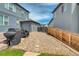 Backyard with gravel ground cover, covered grills, and a wooden fence, between two houses at 965 Arapahoe Cir, Louisville, CO 80027