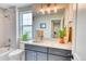 Bathroom with quartz counters, chrome fixtures, grey vanity, and herringbone tile at 965 Arapahoe Cir, Louisville, CO 80027