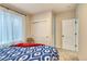 Cozy bedroom with a patterned bedspread, closet, and soft natural light from the window at 965 Arapahoe Cir, Louisville, CO 80027