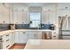 Well-lit kitchen featuring white cabinets, stainless steel appliances, and stylish backsplash at 965 Arapahoe Cir, Louisville, CO 80027
