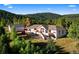 Scenic view of a stunning home nestled amongst a forest with a lush green yard and a separate guest house at 12291 S Critchell Ln, Littleton, CO 80127