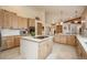 Spacious kitchen with wood cabinets, island cooktop, and eat-in breakfast bar at 12291 S Critchell Ln, Littleton, CO 80127