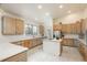 Well-lit kitchen with wood cabinets, stainless appliances, and center island cooktop at 12291 S Critchell Ln, Littleton, CO 80127