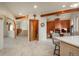 Modern kitchen with light tile flooring and wood cabinets, open to dining area with fireplace at 12291 S Critchell Ln, Littleton, CO 80127