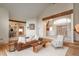 Comfortable living room featuring hardwood floors, beams and a cozy leather couch at 12291 S Critchell Ln, Littleton, CO 80127