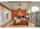 Open living room featuring a custom fireplace, wood beam and access to an outdoor balcony at 12291 S Critchell Ln, Littleton, CO 80127