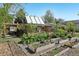 Landscaped backyard with garden beds, brick home, solar panels, and patio area at 805 Union Ave, Boulder, CO 80304
