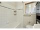 White bathroom with a shower-tub combo, small shelves, and window at 805 Union Ave, Boulder, CO 80304