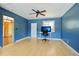 Blue bedroom with hardwood floors, a ceiling fan, and a computer desk by the window at 805 Union Ave, Boulder, CO 80304