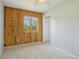 Bright bedroom features wood accent wall, soft carpet, and a large window with outdoor view at 805 Union Ave, Boulder, CO 80304