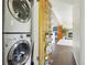 Hallway view of a stacked washer and dryer with shelving and an open door to the living room at 805 Union Ave, Boulder, CO 80304