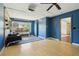 Bright blue living room with projector, ceiling fan, wood wall, and large window at 805 Union Ave, Boulder, CO 80304