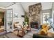 Comfortable living room with a stone fireplace, vaulted ceiling, and access to an outdoor space at 2491 S Xanadu Way # A, Aurora, CO 80014