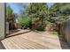 Wood deck with full fence, shade trees and access to sliding glass doors to the interior of the home at 6414 S Hudson St, Centennial, CO 80121