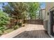Backyard features a deck with a wood fence surround and plenty of shade provided by mature trees at 6414 S Hudson St, Centennial, CO 80121