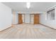 Open finished basement featuring neutral carpet and multiple wood doors at 6414 S Hudson St, Centennial, CO 80121