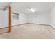 Finished basement featuring neutral carpet, support beams, and a small window at 6414 S Hudson St, Centennial, CO 80121