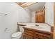 Bathroom with vanity, wood cabinets, large mirror, toilet, and tiled shower at 6414 S Hudson St, Centennial, CO 80121