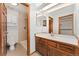 Bathroom featuring a walk in shower, tile, and vanity with wood cabinets and a skylight at 6414 S Hudson St, Centennial, CO 80121