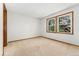 A light and airy bedroom with neutral walls and carpet features two windows at 6414 S Hudson St, Centennial, CO 80121