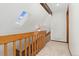 Upstairs hallway with a skylight, wooden railing, and neutral carpet at 6414 S Hudson St, Centennial, CO 80121