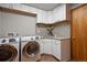 Functional laundry room with modern washer and dryer and ample cabinet space at 19890 Indian Summer Ln, Monument, CO 80132