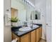 Well-lit bathroom features double sinks, oak cabinets and large vanity mirror at 14700 E 104Th Ave # 2605, Commerce City, CO 80022