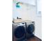 Modern laundry room with front loading washer and dryer and wire shelving for organization at 14700 E 104Th Ave # 2605, Commerce City, CO 80022