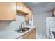 Functional kitchen area with a double stainless steel sink and white tiled countertops and backsplash at 2225 Buchtel Blvd # 1003, Denver, CO 80210