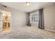 Bedroom featuring a large window, neutral walls, and an en-suite bathroom at 9481 E Mansfield Ave # 301, Aurora, CO 80014