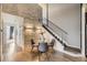 Cozy dining area features a glass table, modern chairs, a stacked stone accent wall, and staircase access at 9481 E Mansfield Ave # 301, Aurora, CO 80014