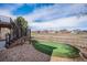 Expansive backyard with a putting green, iron fencing and views of neighboring houses and open space at 26989 E Friend Pl, Aurora, CO 80016