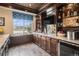 A fully equipped wet bar showcases a sink, wine fridge, and display shelves, complemented by elegant finishes at 26989 E Friend Pl, Aurora, CO 80016