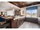 A stylish bar area features custom cabinetry, granite countertops, and wood floors, adjacent to a built-in bookcase at 26989 E Friend Pl, Aurora, CO 80016