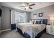 Comfortable bedroom featuring a stylish patterned comforter, ceiling fan, and a bright window at 26989 E Friend Pl, Aurora, CO 80016