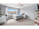 Bright bedroom features a ceiling fan, large window, and modern furnishings at 26989 E Friend Pl, Aurora, CO 80016