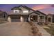 Charming two-story home featuring stone accents, a covered porch, and a spacious two-car garage at 26989 E Friend Pl, Aurora, CO 80016